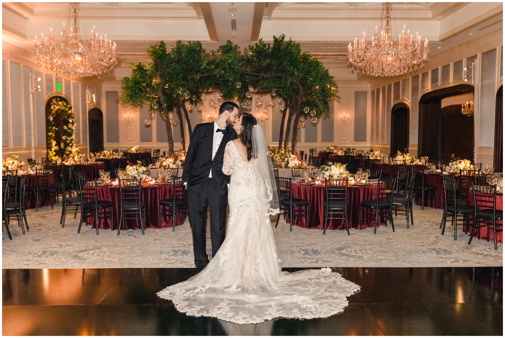 A bride and groom kiss while seeing their completed reception hall for the first time at their Dallas Country Club Wedding