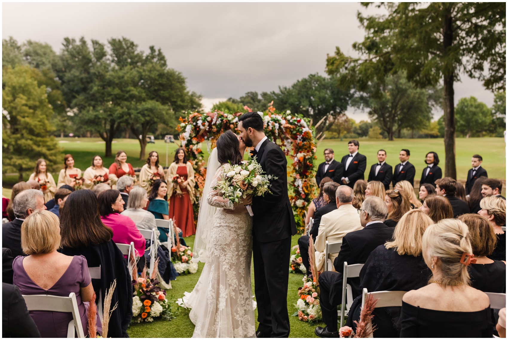 Newlyweds kiss in the aisle while exiting their Dallas Country Club Wedding ceremony