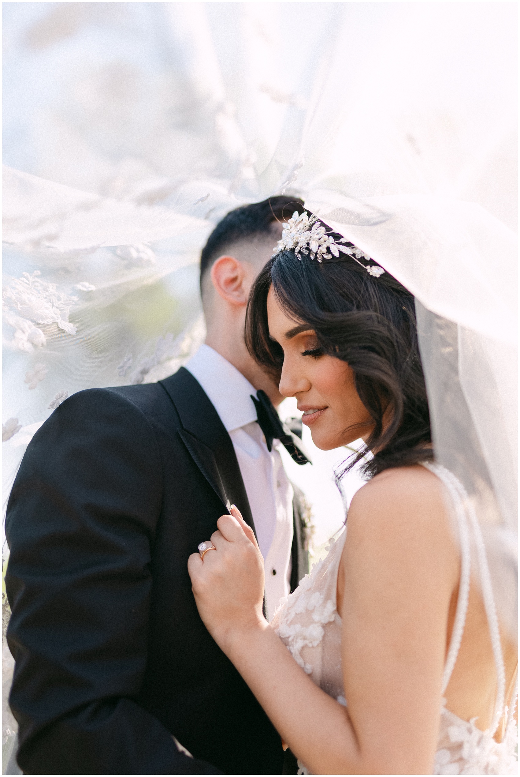 Newlyweds hide and dance under the veil with lace embroidery