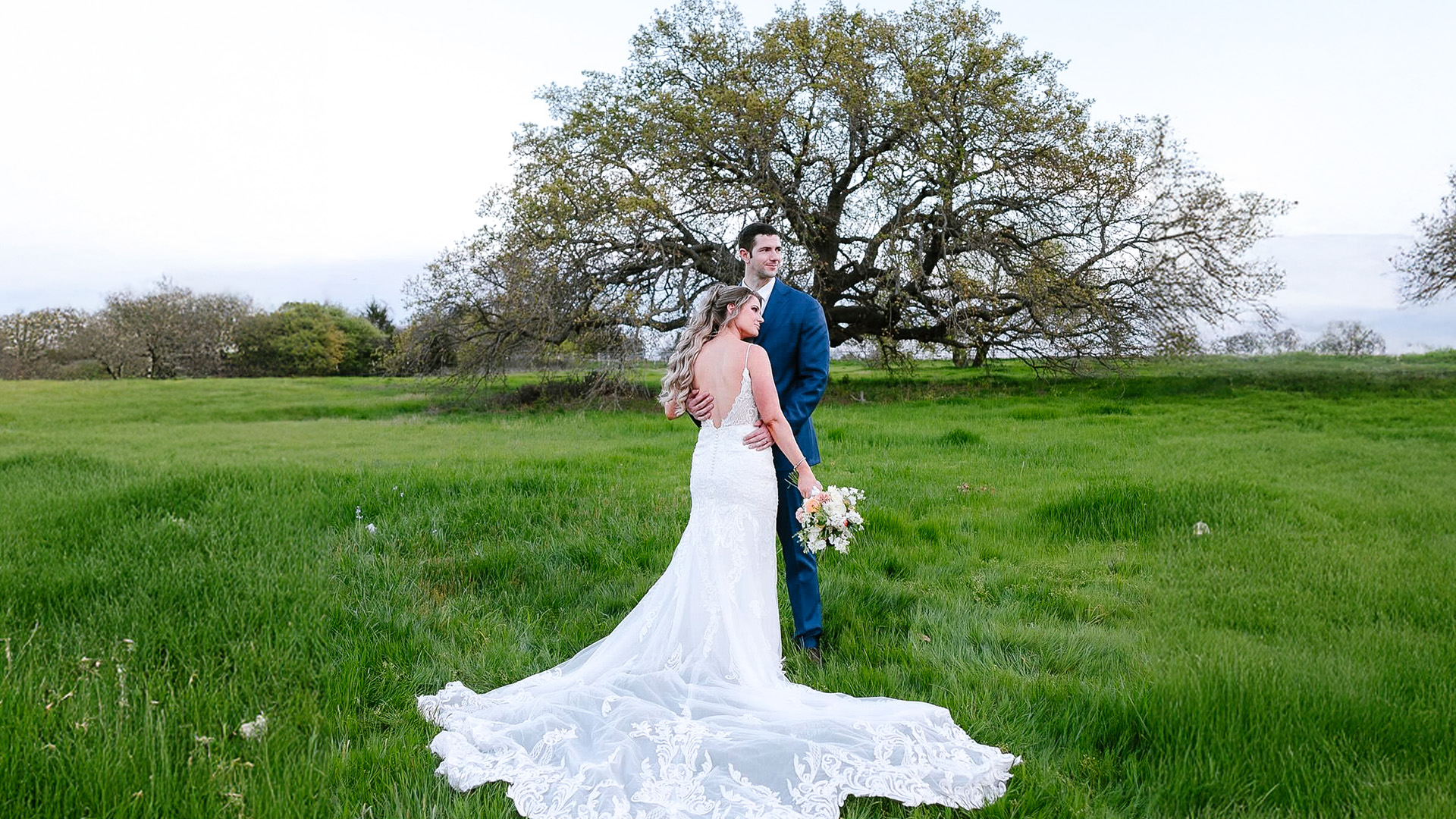 Newlyweds share a peaceful moment holding on to each other by a tree at The Flying V Ranch