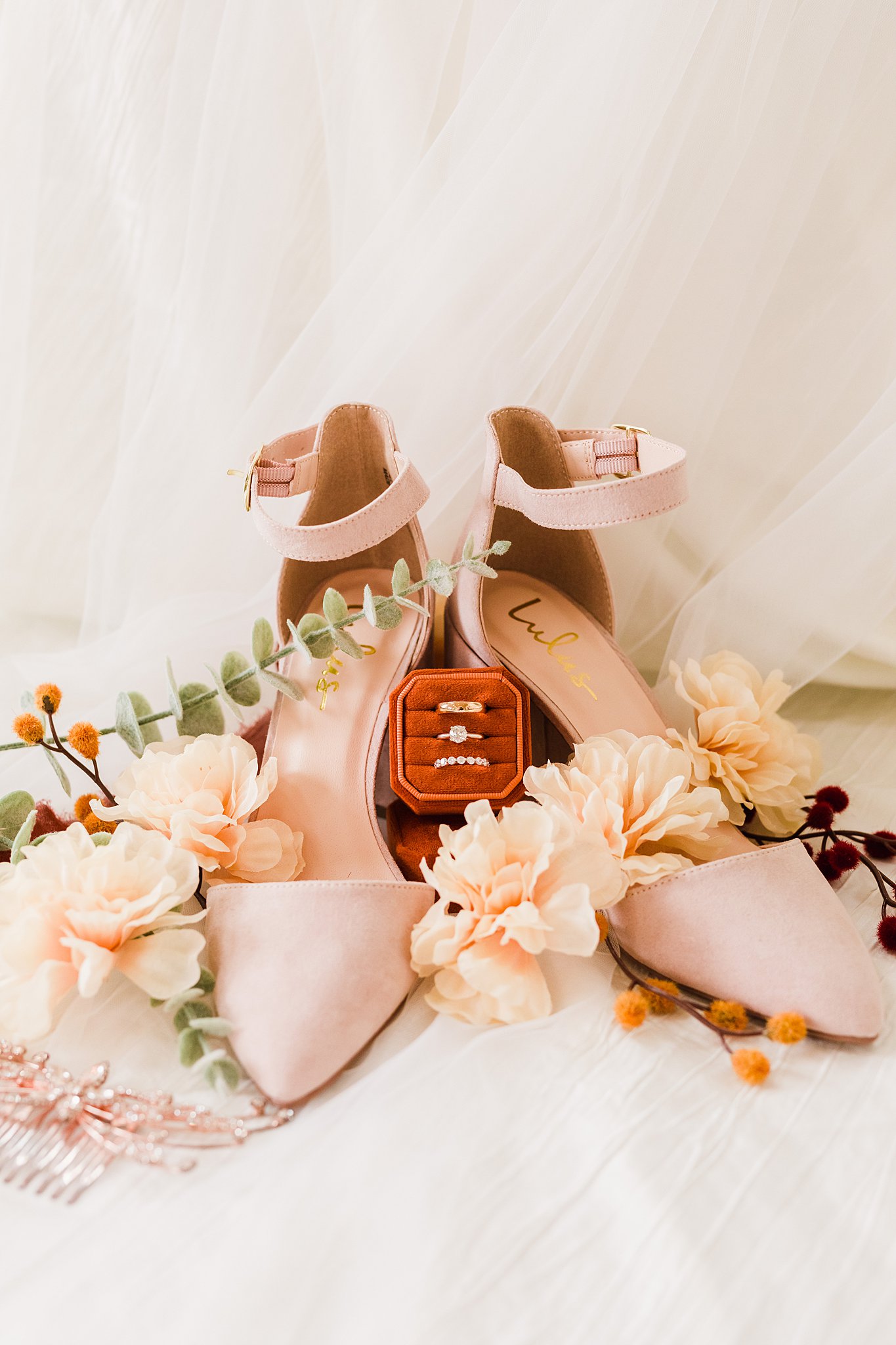 Bridal details with pink shoes and matching roses around wedding rings and box at a Chateau Jolli wedding