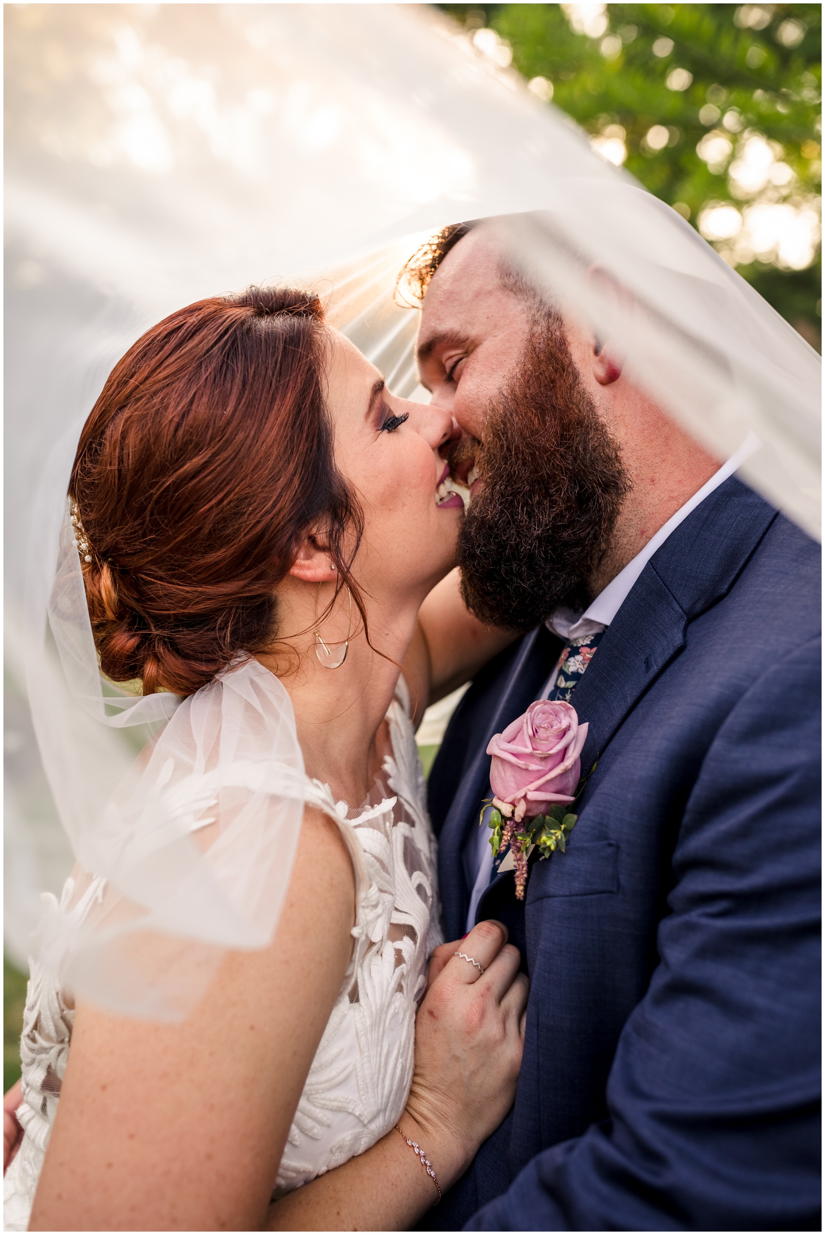 Newlyweds laugh and kiss while hiding under the veil at sunset during their D'Vine Grace Vineyard wedding