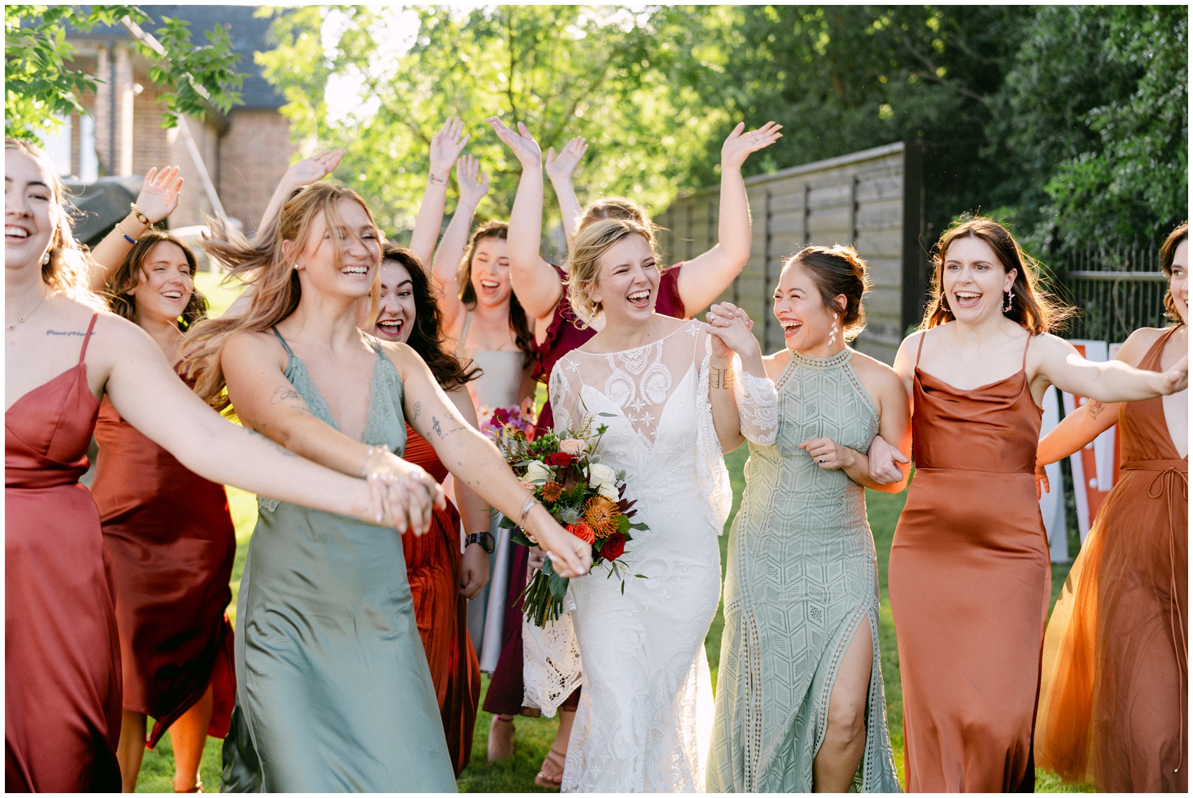 A bride laughs and walks through a garden holding hands and celebrating before her Firefly Gardens Wedding