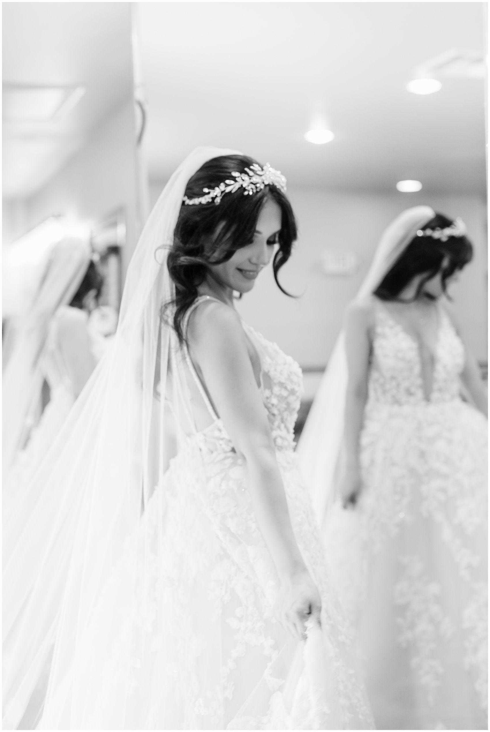 A bride shows off her lace dress in a large mirror at her Hillside Estate Wedding