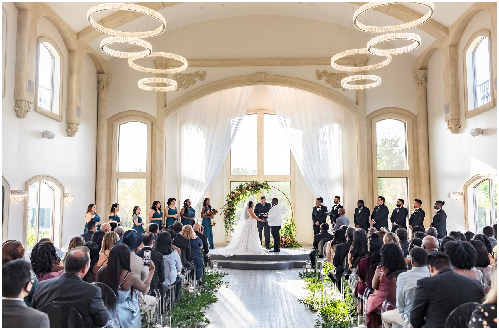 A bride and groom hold hands at the altar during their indoor wedding ceremony