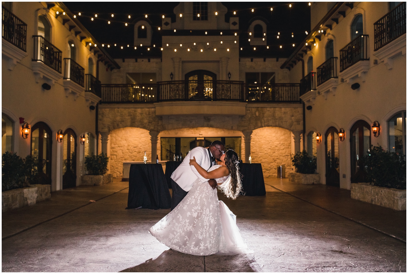 A groom dips and kisses his bride on the dance floor under market lights at the Knotting Hill Place Wedding venue