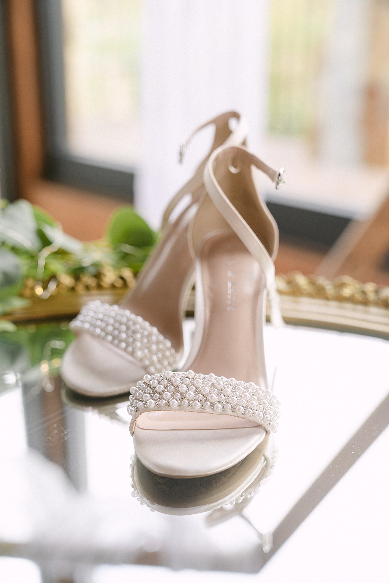 Details of bridal shoes on a mirror table