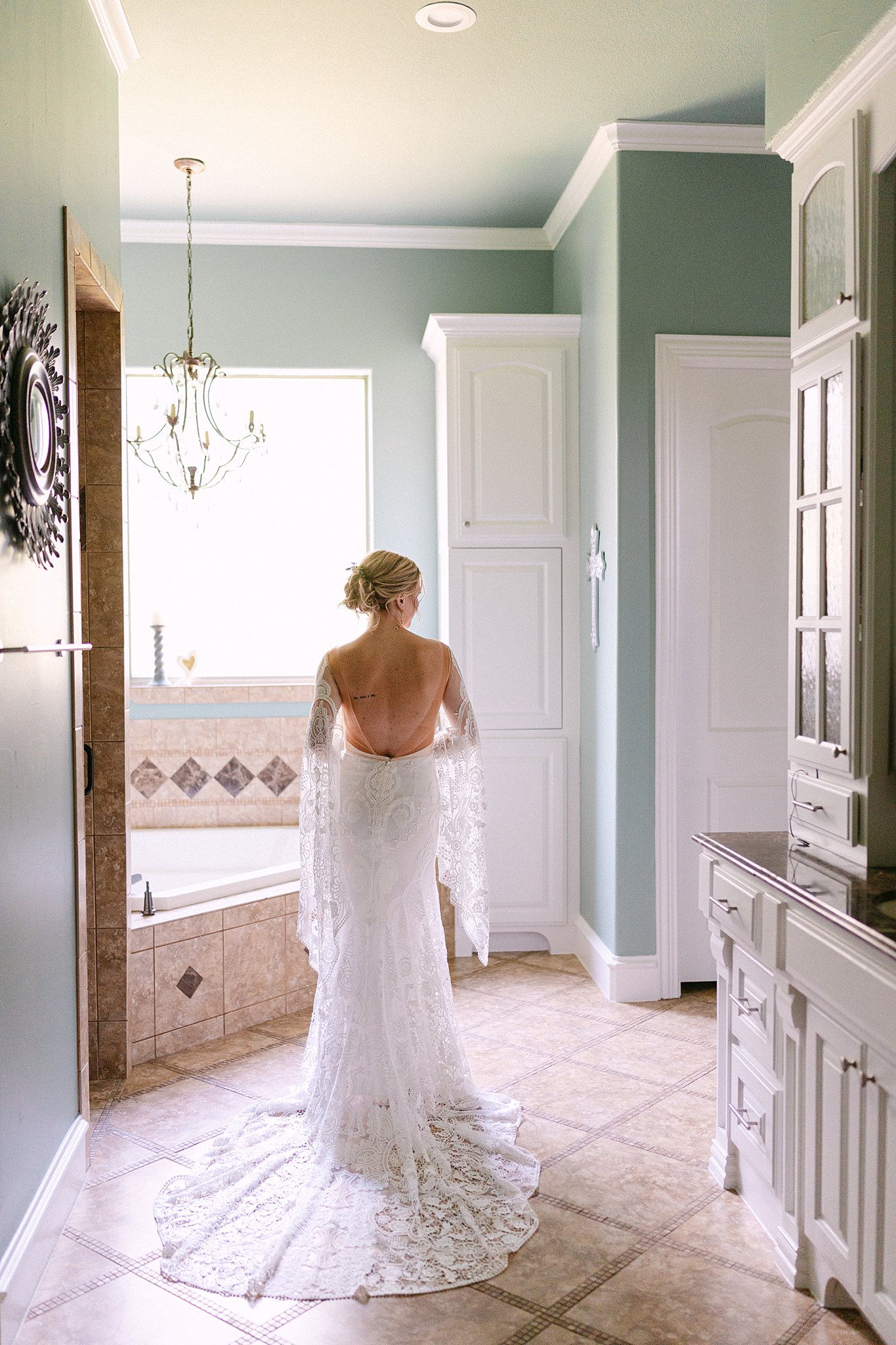 A bride admires her dress in a bathroom