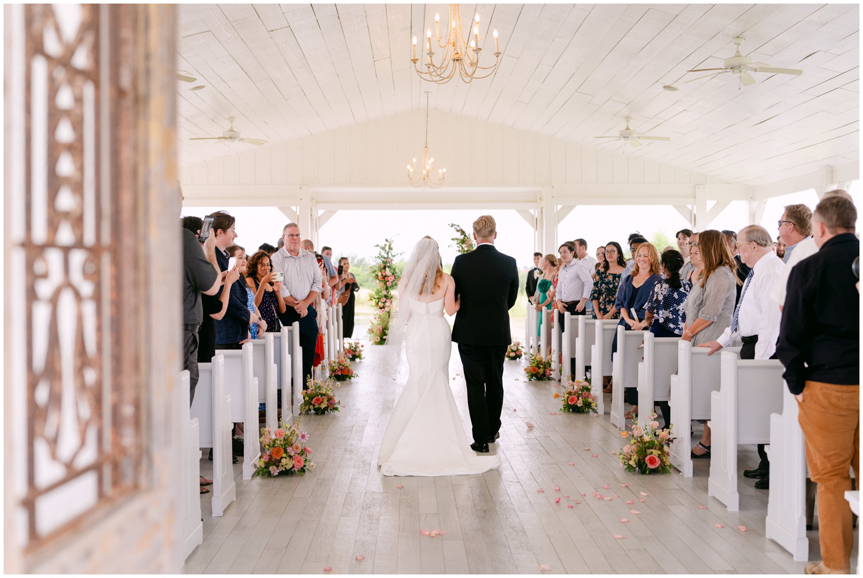 A bride walks down the aisle to her ceremony at The Grand Ivory Wedding Venue