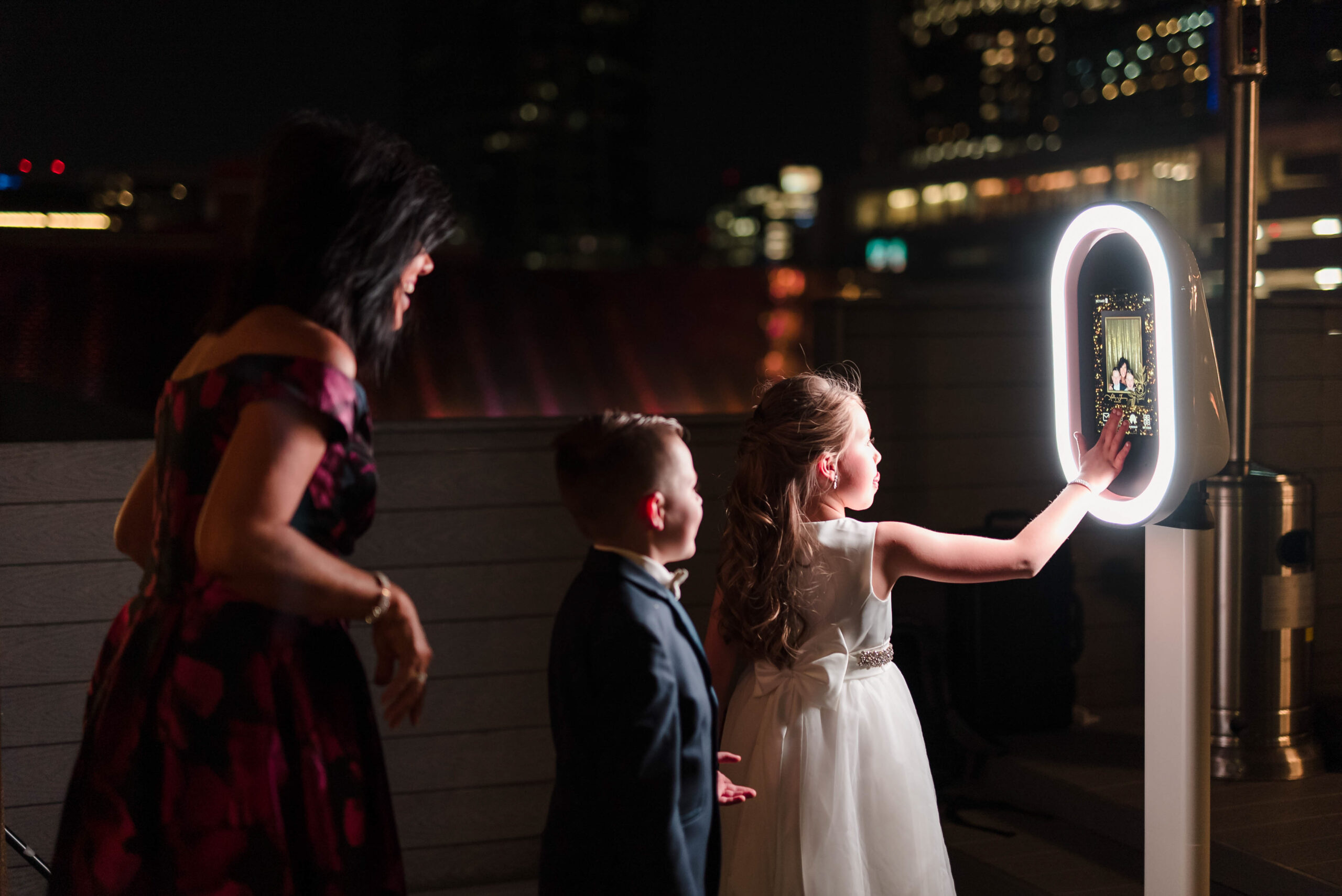 Young kids having fun and playing with a DFW Photo Booth at a wedding