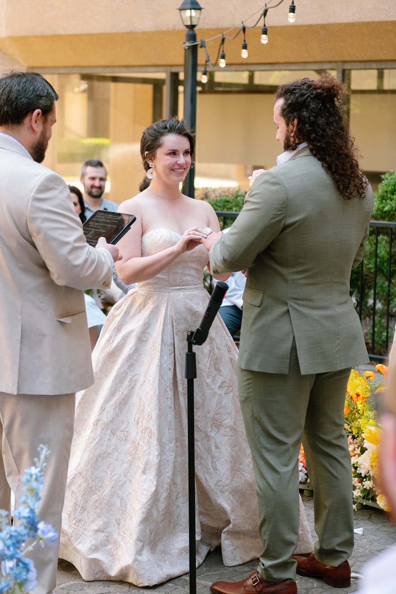 Bride and groom exchanging vows during wedding photo and video coverage